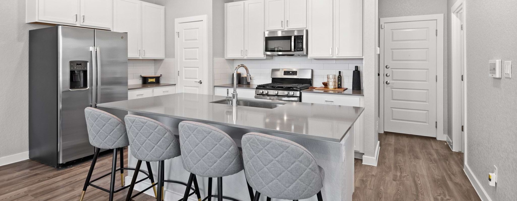 Kitchen with white cabinets and quartz countertops at Frame Med Center homes for rent, San Antonio, TX.